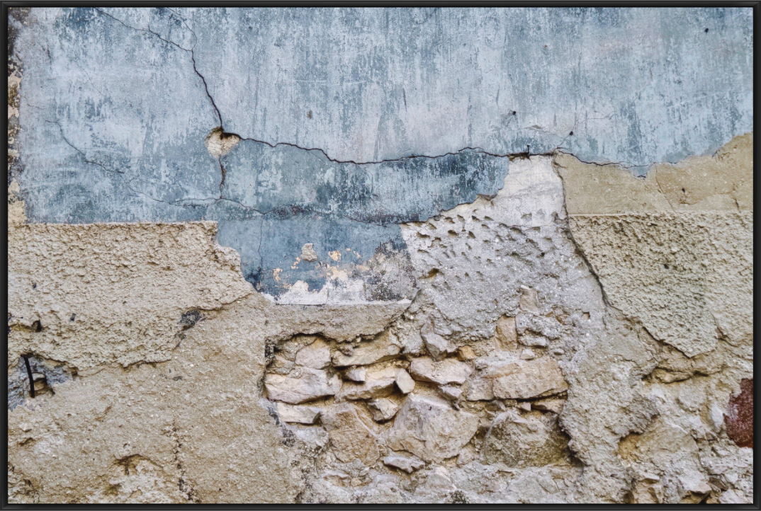 Verwitterte Mauer mit Rissen und freigelegtem Mauerwerk